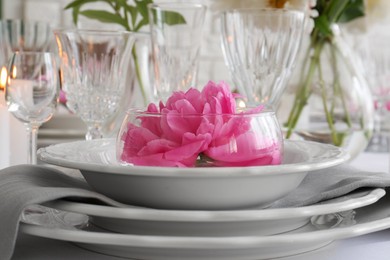 Photo of Stylish table setting with beautiful peony in dining room, closeup