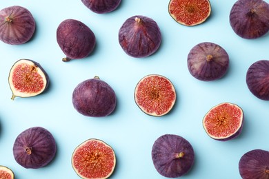 Fresh ripe purple figs on light blue background, flat lay