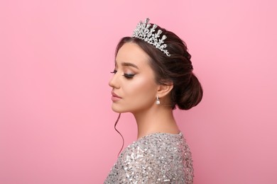 Photo of Beautiful young woman wearing luxurious tiara on pink background