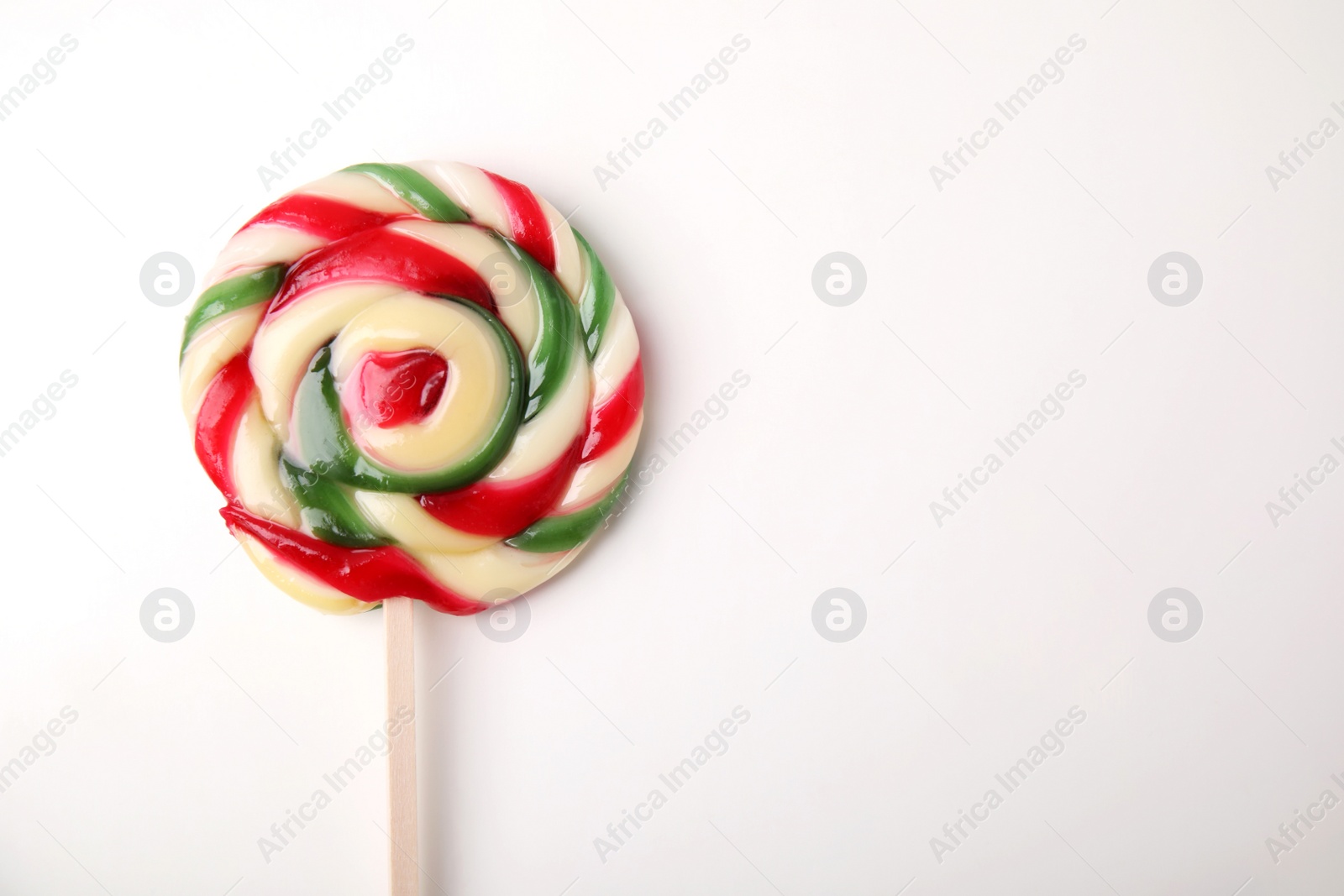 Photo of Colorful lollipop on white background, top view. Space for text