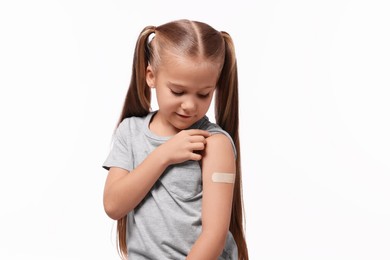Photo of Girl with sticking plaster on arm after vaccination against white background