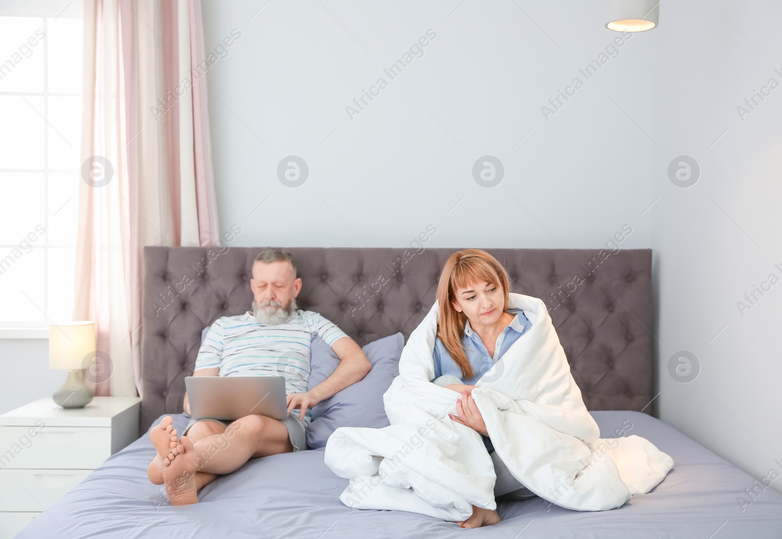Photo of Mature couple with problem in relationship on bed at home