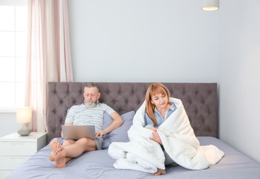 Photo of Mature couple with problem in relationship on bed at home