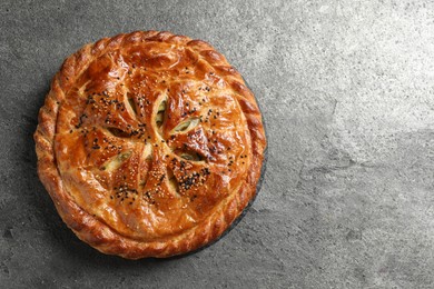 Photo of Tasty homemade pie with filling on grey table, top view. Space for text