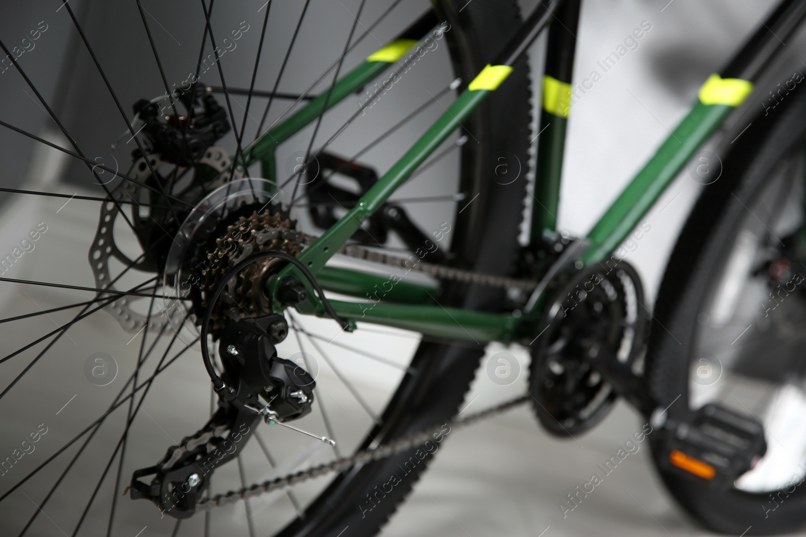 Photo of Modern green bicycle on floor indoors, closeup