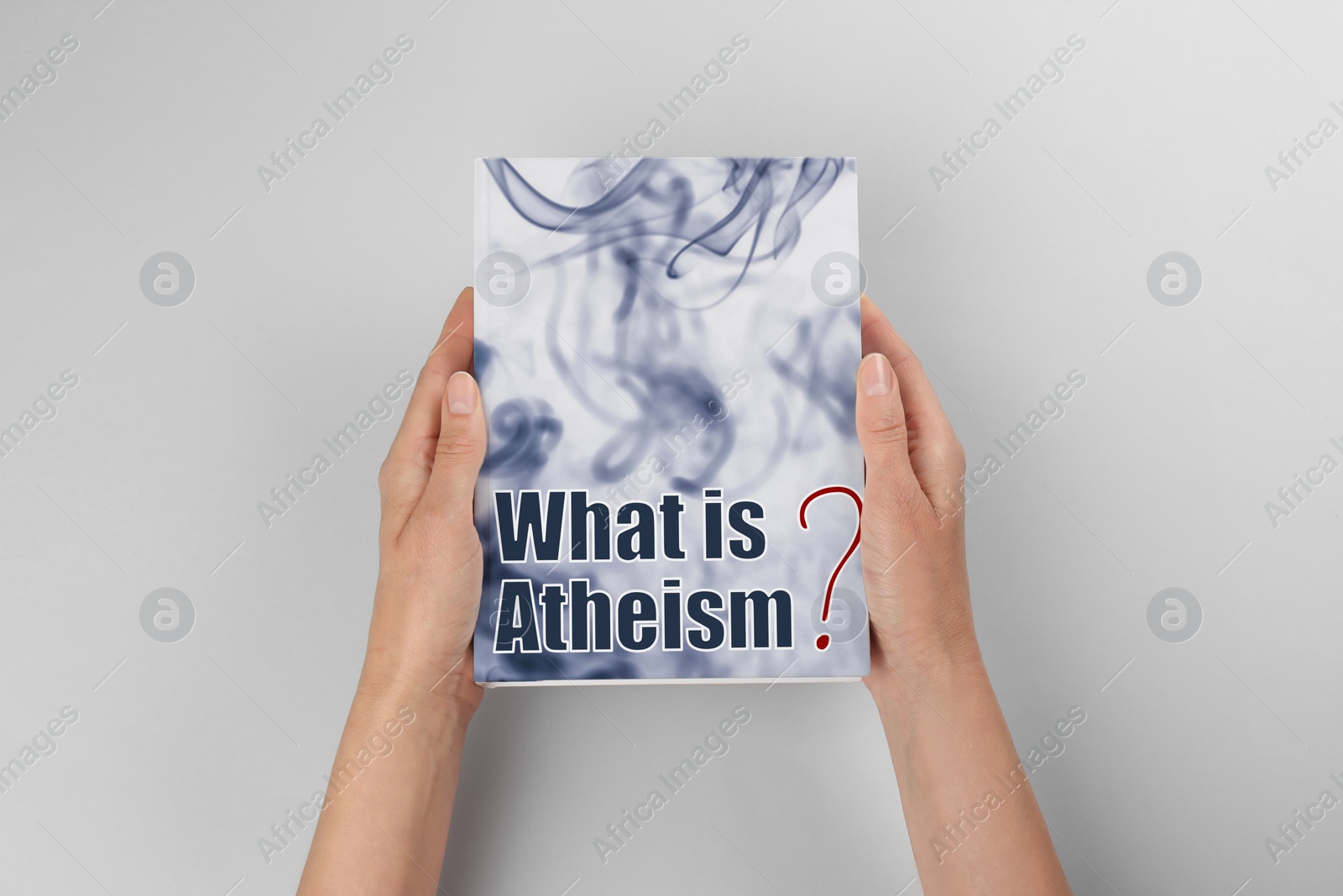 Image of Woman holding book about atheism on light background, top view