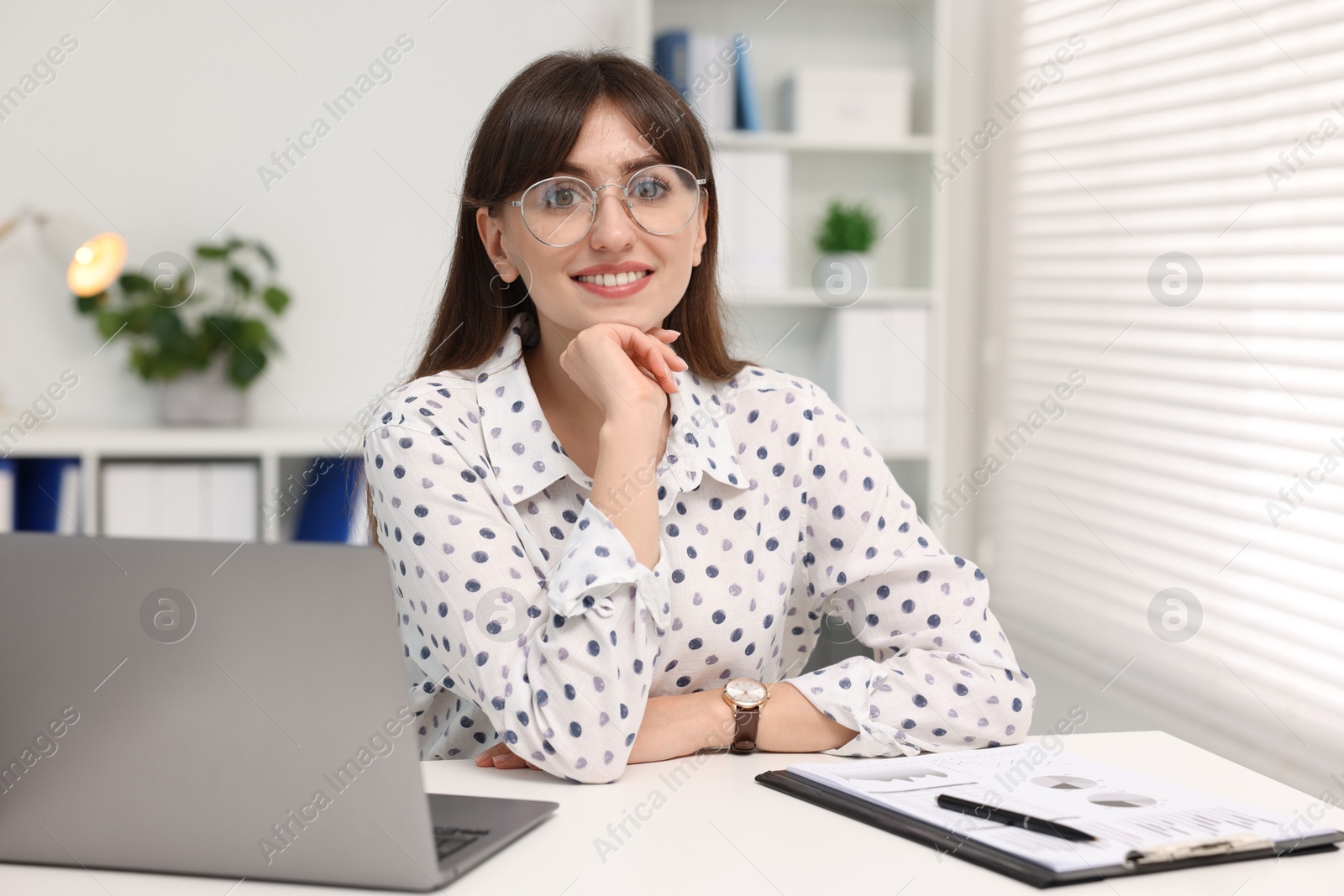 Photo of Portrait of smiling secretary at table in office