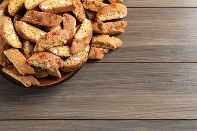 Photo of Traditional Italian almond biscuits (Cantucci) on wooden table, flat lay. Space for text