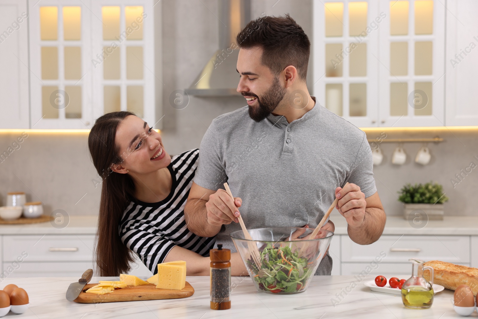 Photo of Lovely young couple cooking together in kitchen