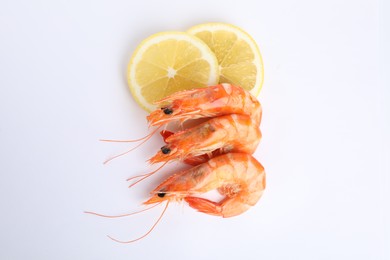 Photo of Delicious cooked shrimps and lemon isolated on white, top view