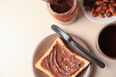 Photo of Tasty toast with chocolate paste and cup of tea served on light table, flat lay. Space for text