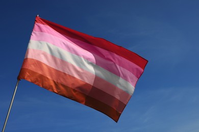 Bright lesbian flag fluttering against blue sky