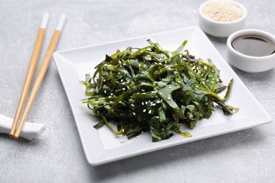 Fresh laminaria (kelp) seaweed served on light gray table