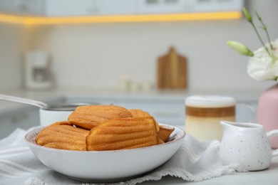 Photo of Tasty madeleine cookies on table in kitchen