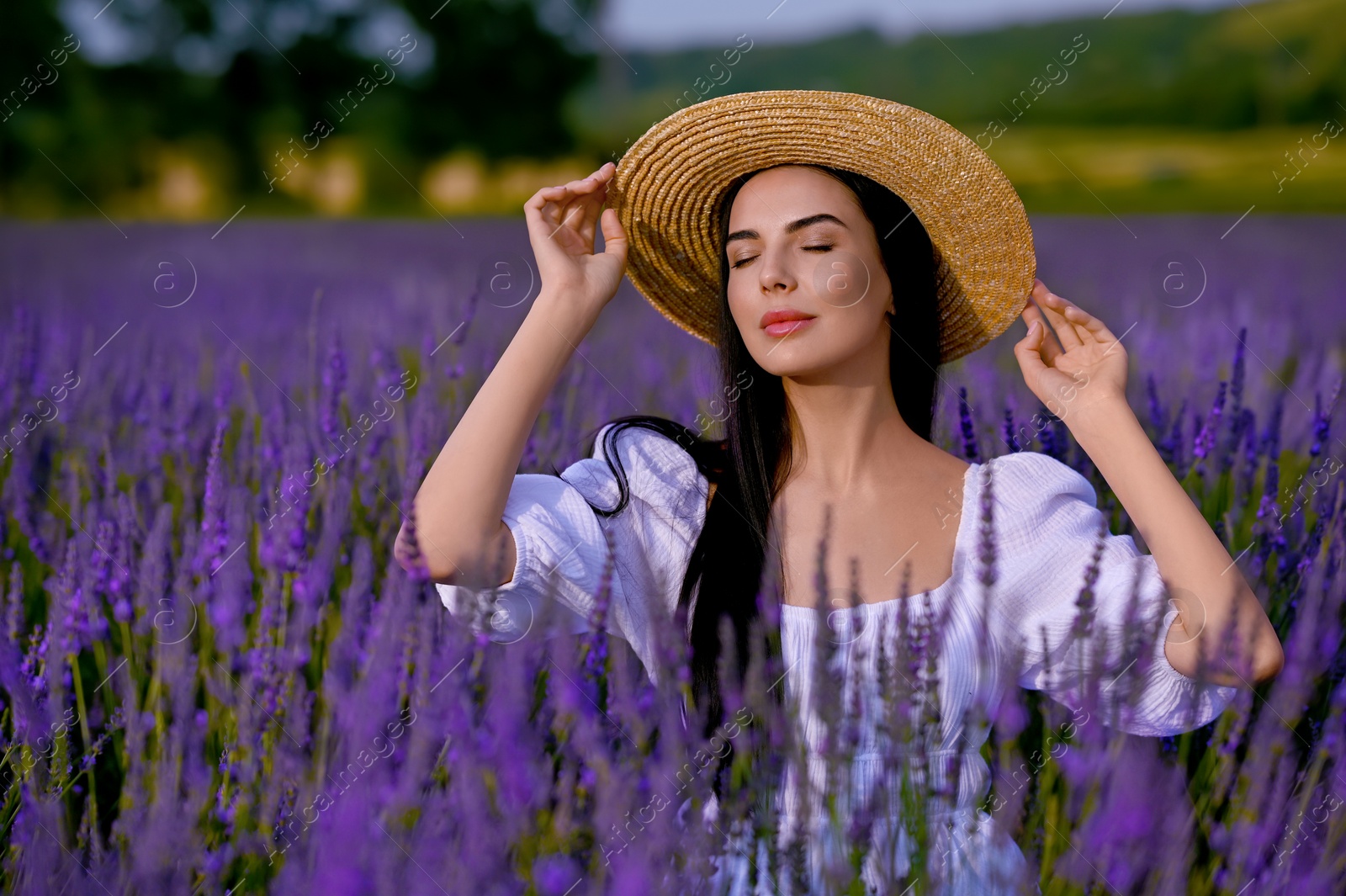 Photo of Beautiful young woman with straw hat in lavender field