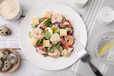 Photo of Delicious Caesar salad with shrimps and ingredients on white wooden table, flat lay