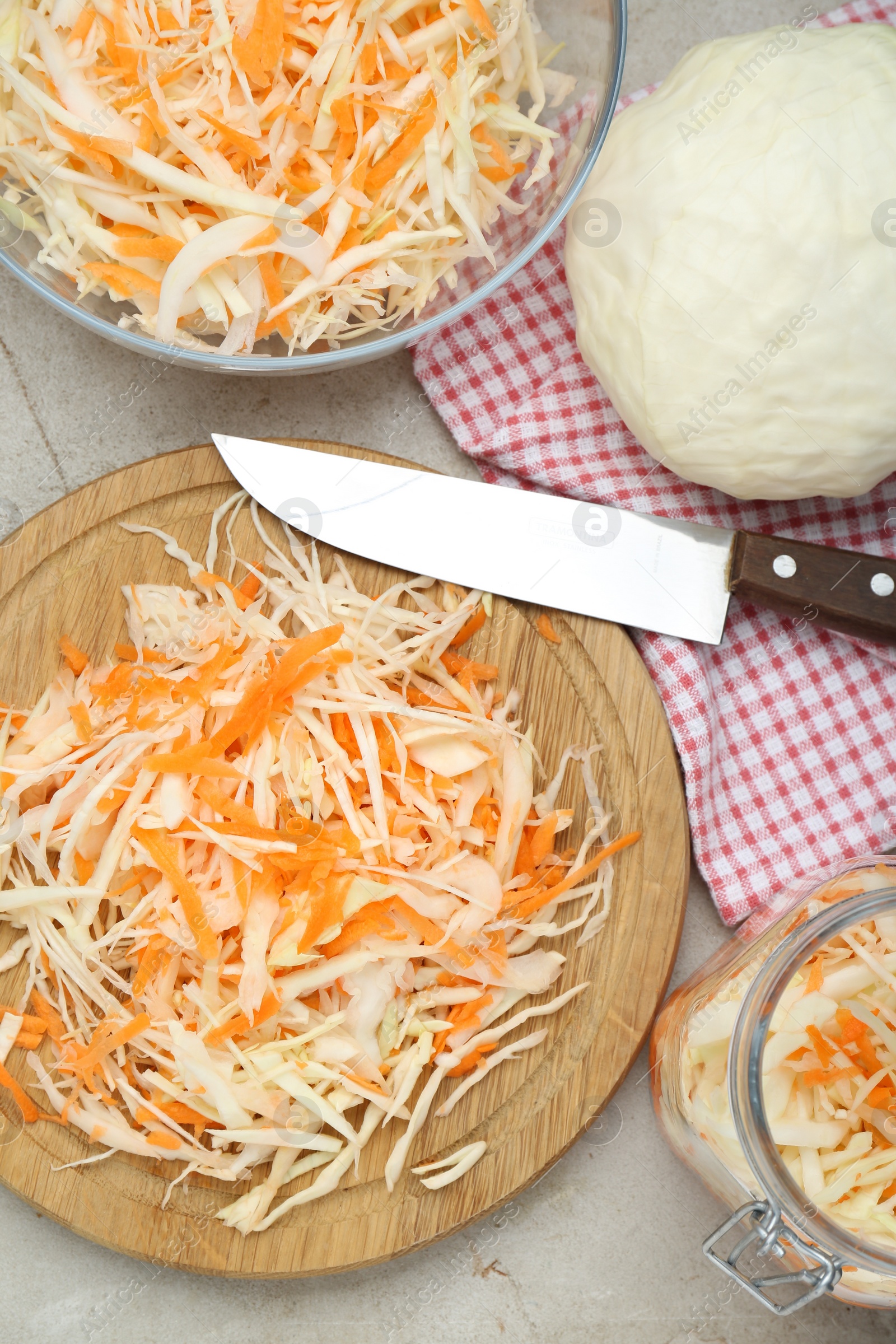Photo of Cooking delicious sauerkraut soup. Fresh chopped carrot and cabbage on light grey table, flat lay