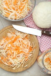 Cooking delicious sauerkraut soup. Fresh chopped carrot and cabbage on light grey table, flat lay