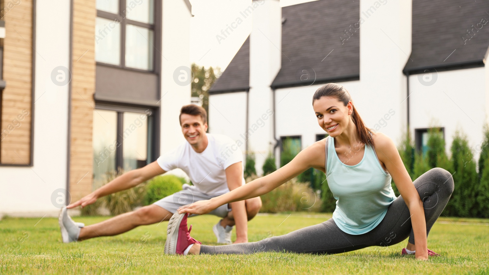 Photo of Sporty couple practicing morning yoga at backyard. Healthy lifestyle