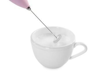 Whisking milk in cup with mini mixer (frother wand) isolated on white