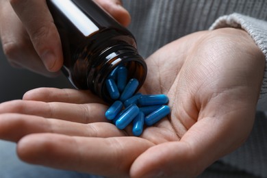 Photo of Man pouring pills from bottle, closeup view