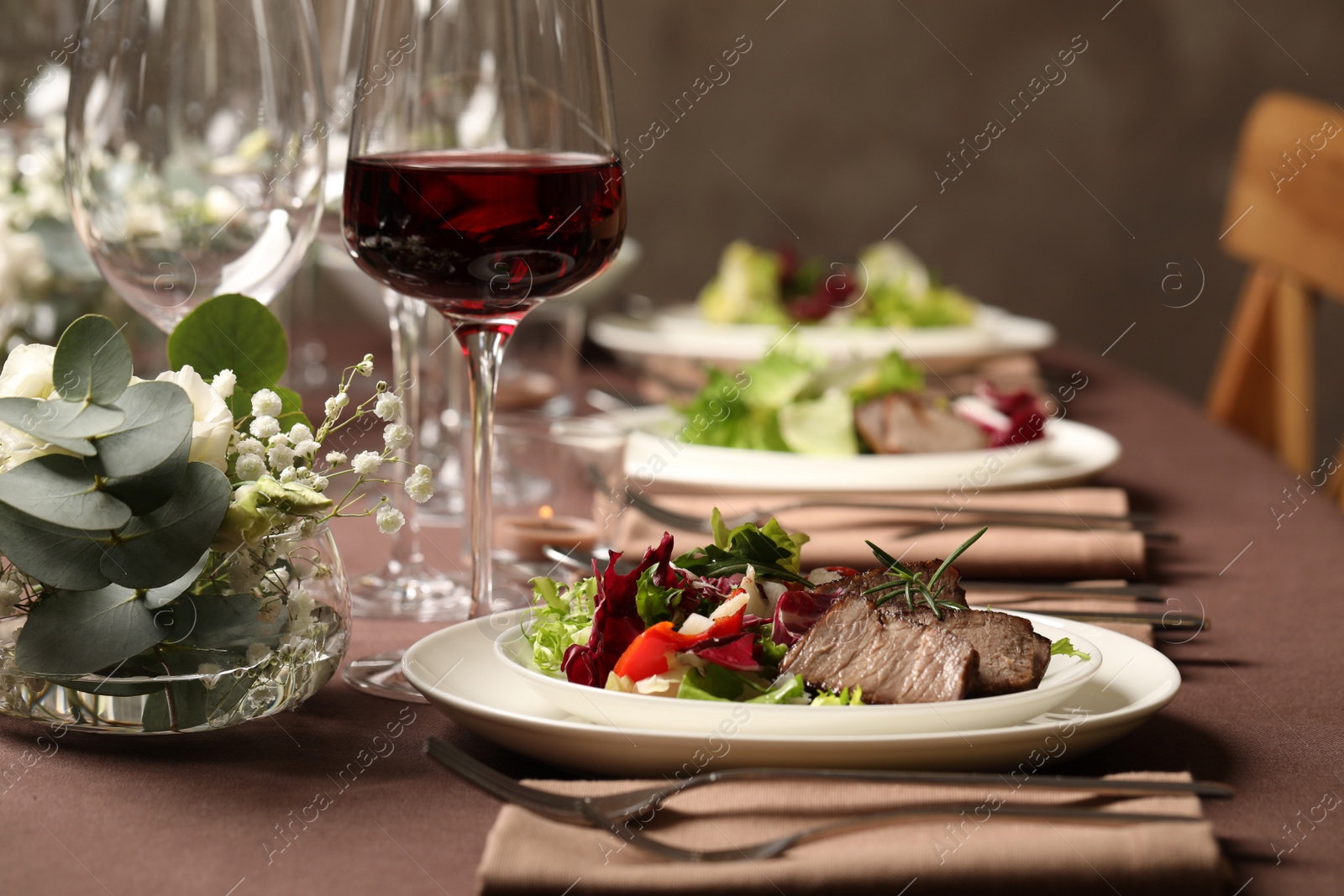 Photo of Delicious grilled meat with vegetables and wine served on table in restaurant