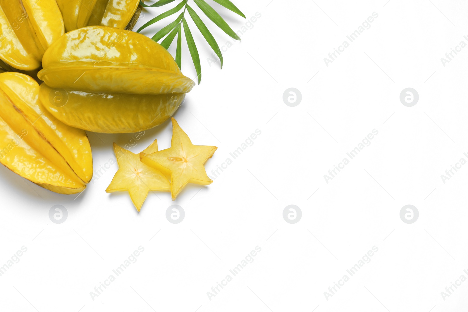 Photo of Delicious carambola fruits and leaves on white background, flat lay