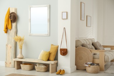 Photo of Hallway interior with wooden bench, clothes and mirror