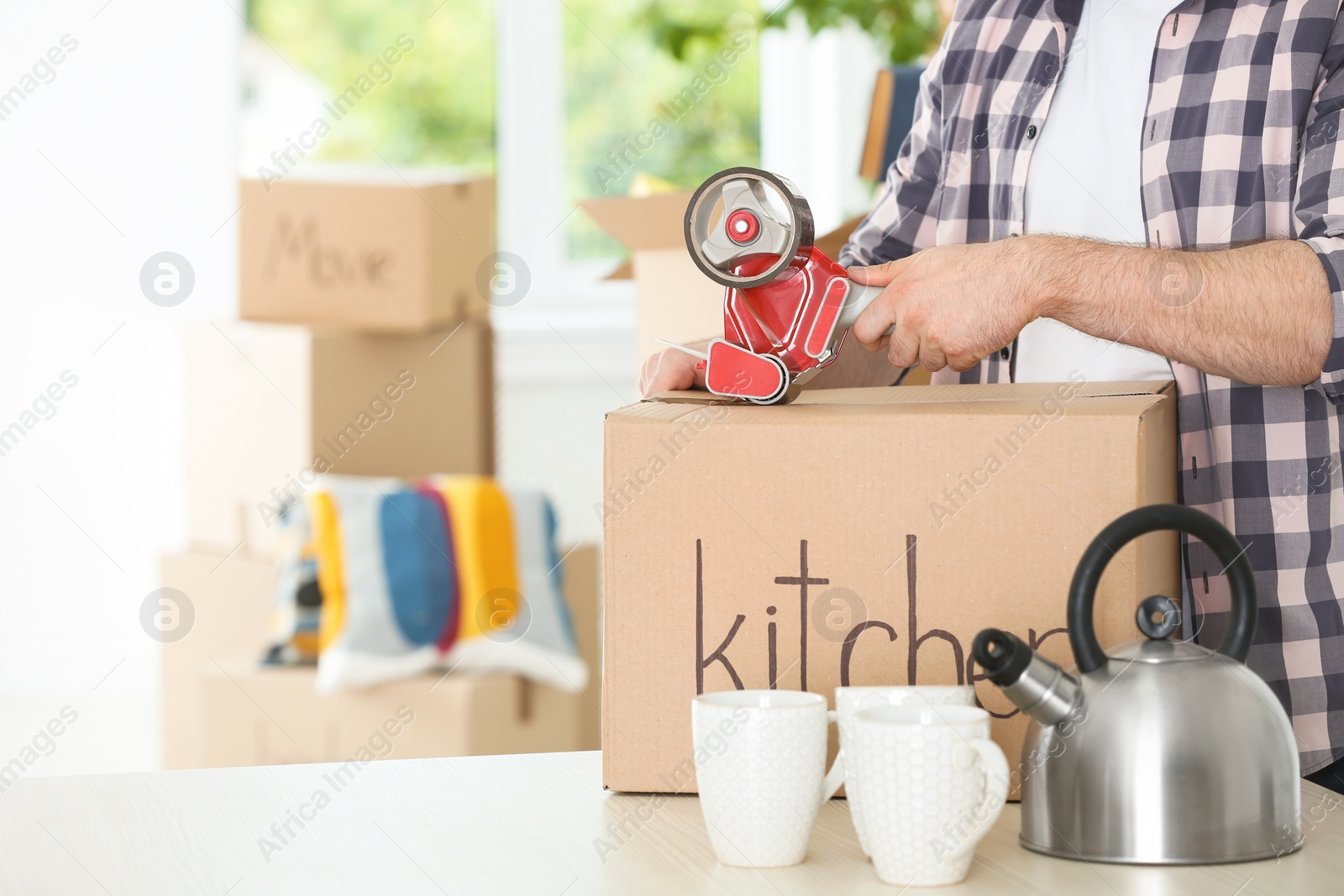 Photo of Man packing moving box indoors, closeup. Space for text