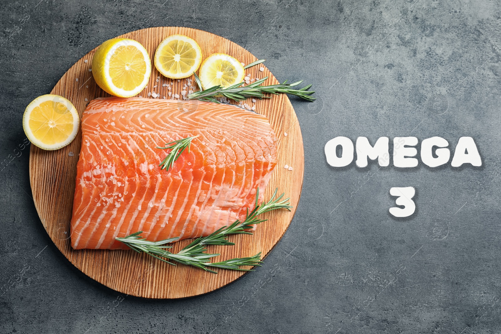 Image of Omega 3. Piece of fresh salmon with salt, rosemary and lemon on grey table, top view