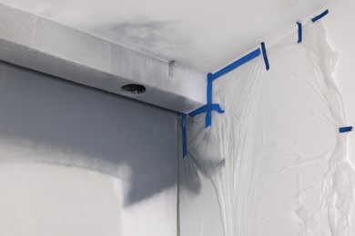 Photo of White fresh painted wall covered with plastic film