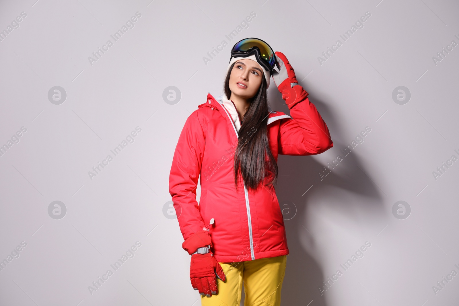 Photo of Woman wearing stylish winter sport clothes on light grey background