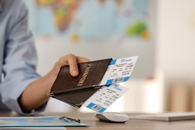 Travel agent with tickets and passports in office, closeup
