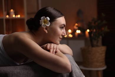 Photo of Spa therapy. Beautiful young woman lying on massage table in salon, space for text