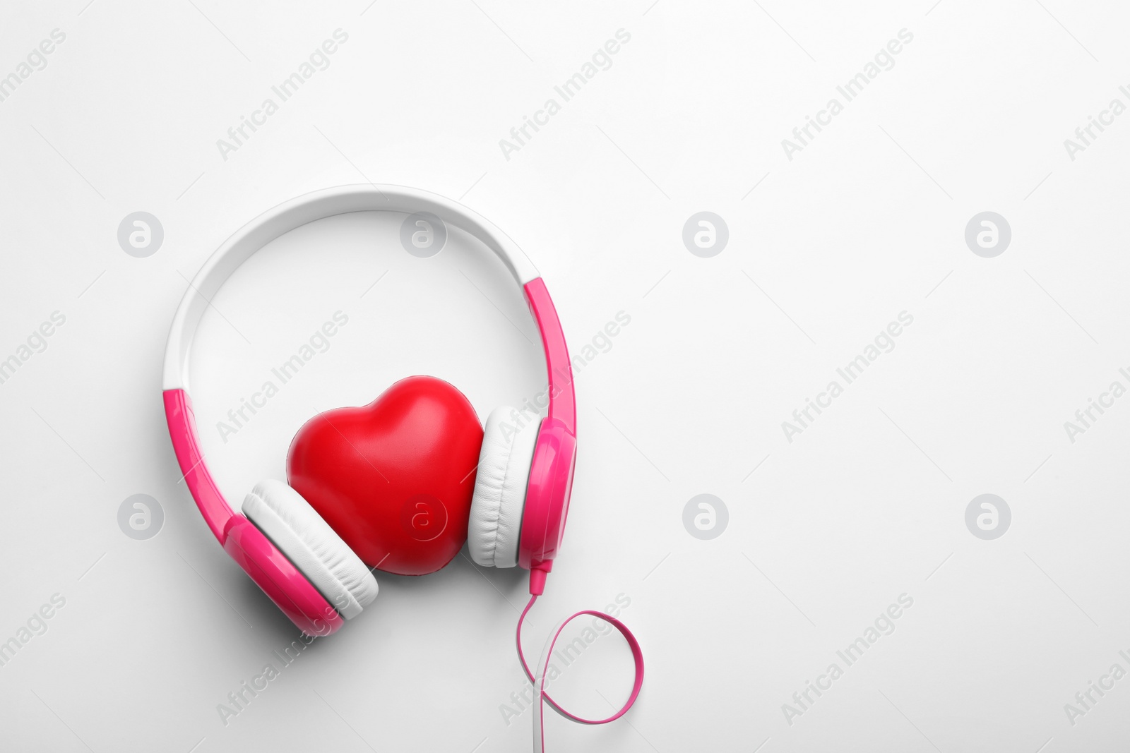 Photo of Decorative heart and modern headphones on white background, top view