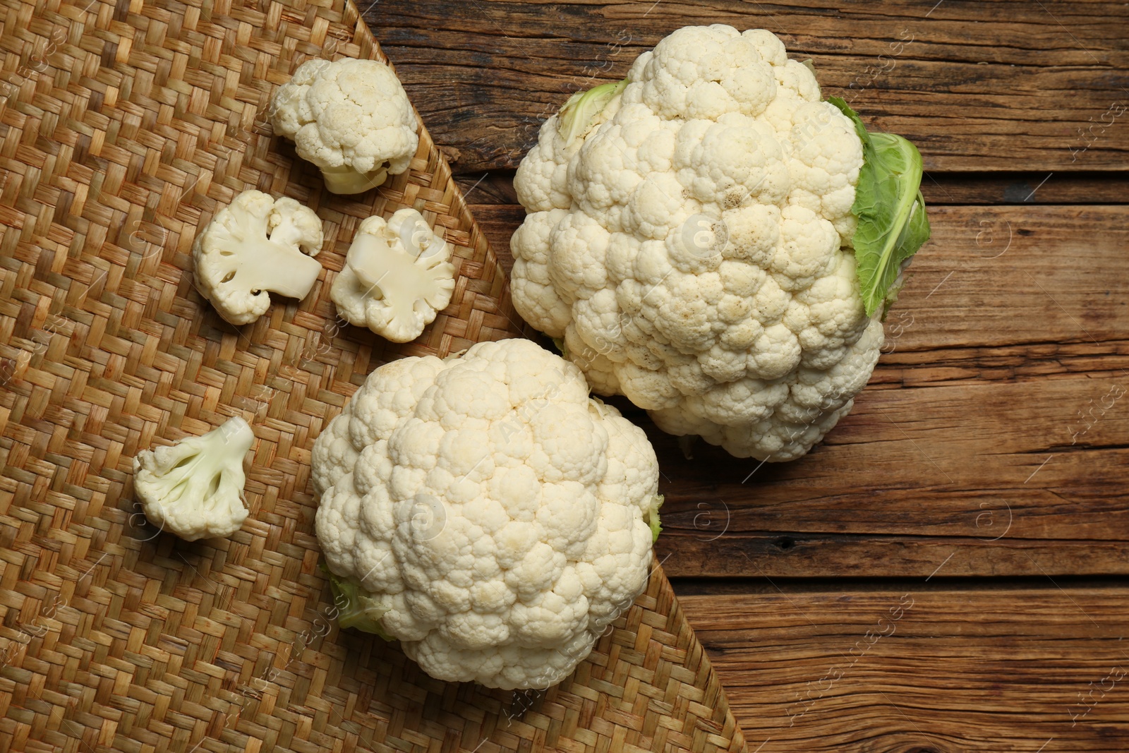 Photo of Fresh cauliflower on wooden table, top view. Space for text