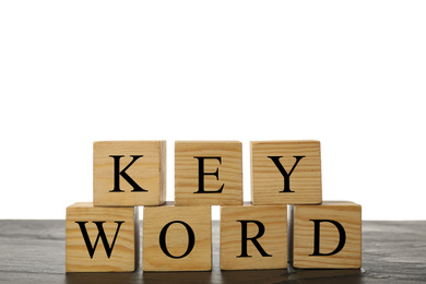 Photo of Wooden cubes with word KEYWORD on grey table, closeup