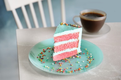 Slice of fresh delicious birthday cake on table indoors