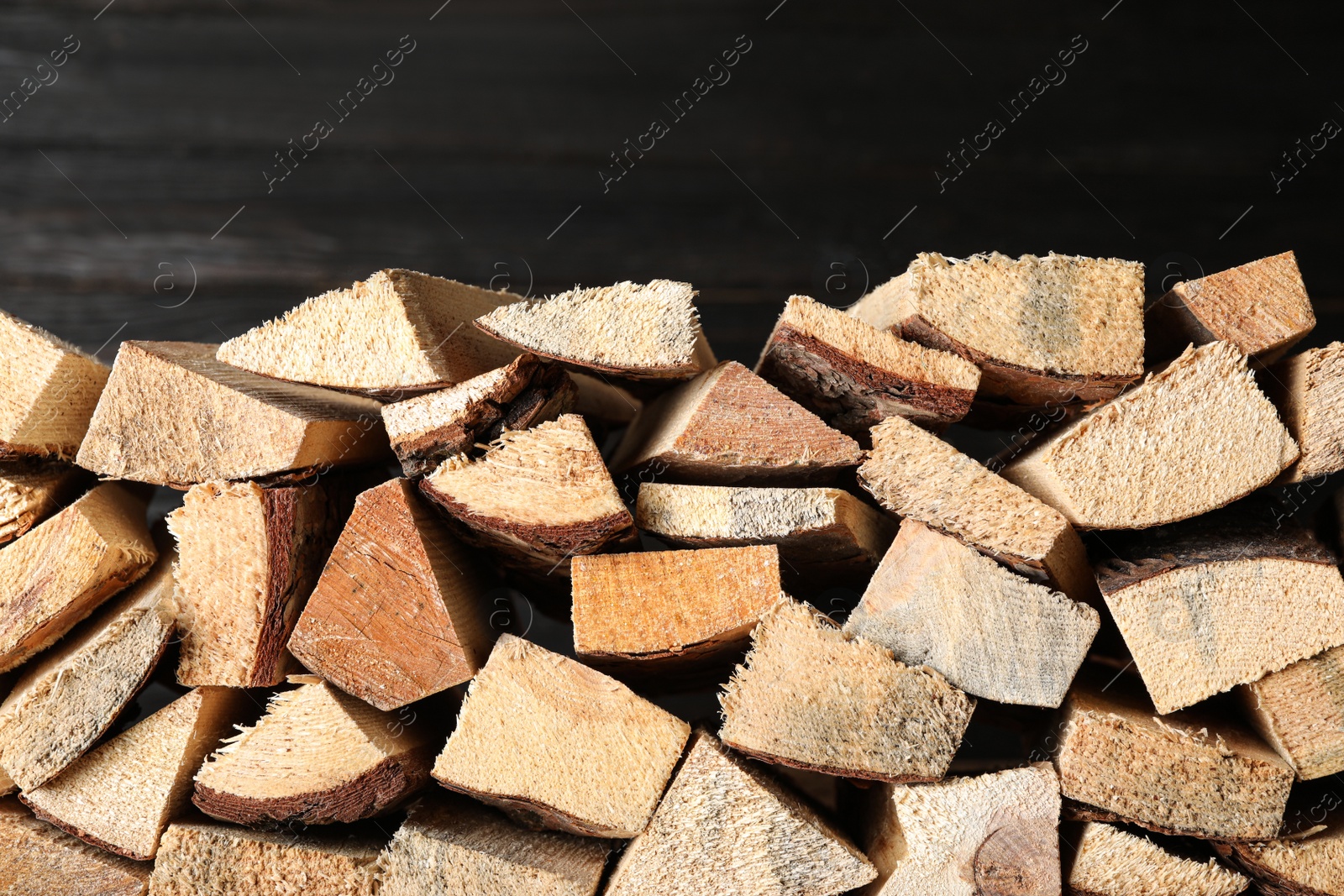 Photo of Cut firewood on black background. Heating in winter