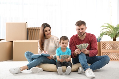 Photo of Happy family with money on floor at home