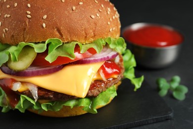 Delicious burger with beef patty on dark table, closeup. Space for text