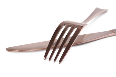 Photo of New shiny fork and knife on white background, closeup
