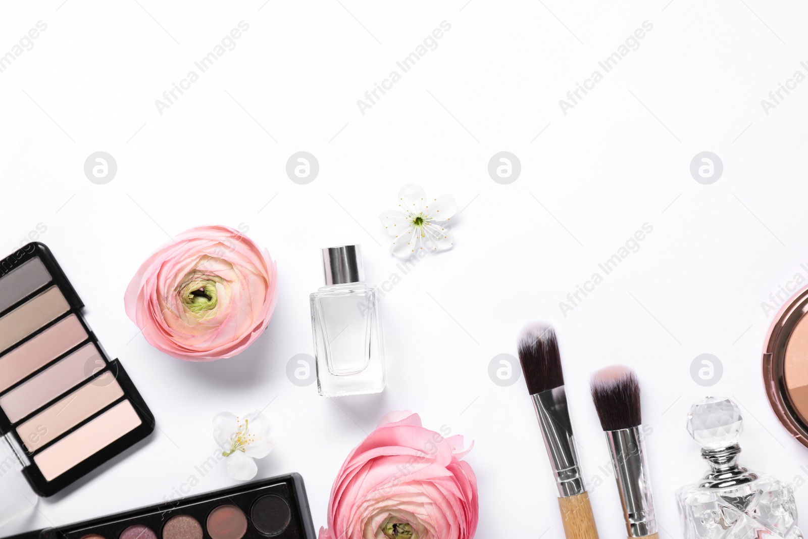 Photo of Flat lay composition with different makeup products and beautiful spring flowers on white background, space for text