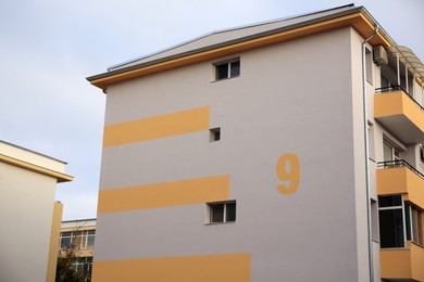 House number nine on beige wall outdoors
