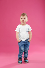 Photo of Cute little boy posing on pink background