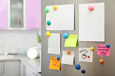 Photo of Many notes and empty sheets with magnets on refrigerator door in kitchen. Space for text