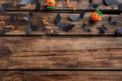 Photo of Halloween decor elements on wooden background, flat lay. Space for text