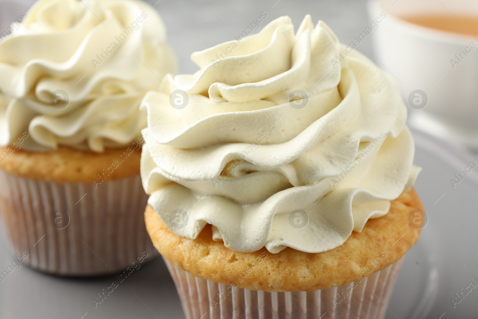 Photo of Tasty cupcakes with vanilla cream on table, closeup