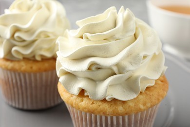 Photo of Tasty cupcakes with vanilla cream on table, closeup