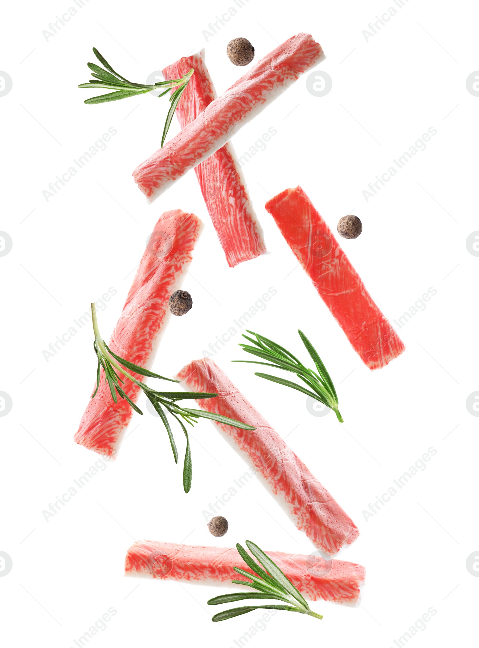 Image of Cut fresh crab sticks, rosemary and allspice falling on white background